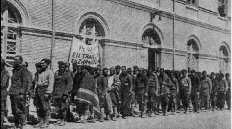 Prisioneros llegando a San Juan de Mozarrifar con un cartel que lee “Entramos en Zaragoza” el 14 de mayo de 1938